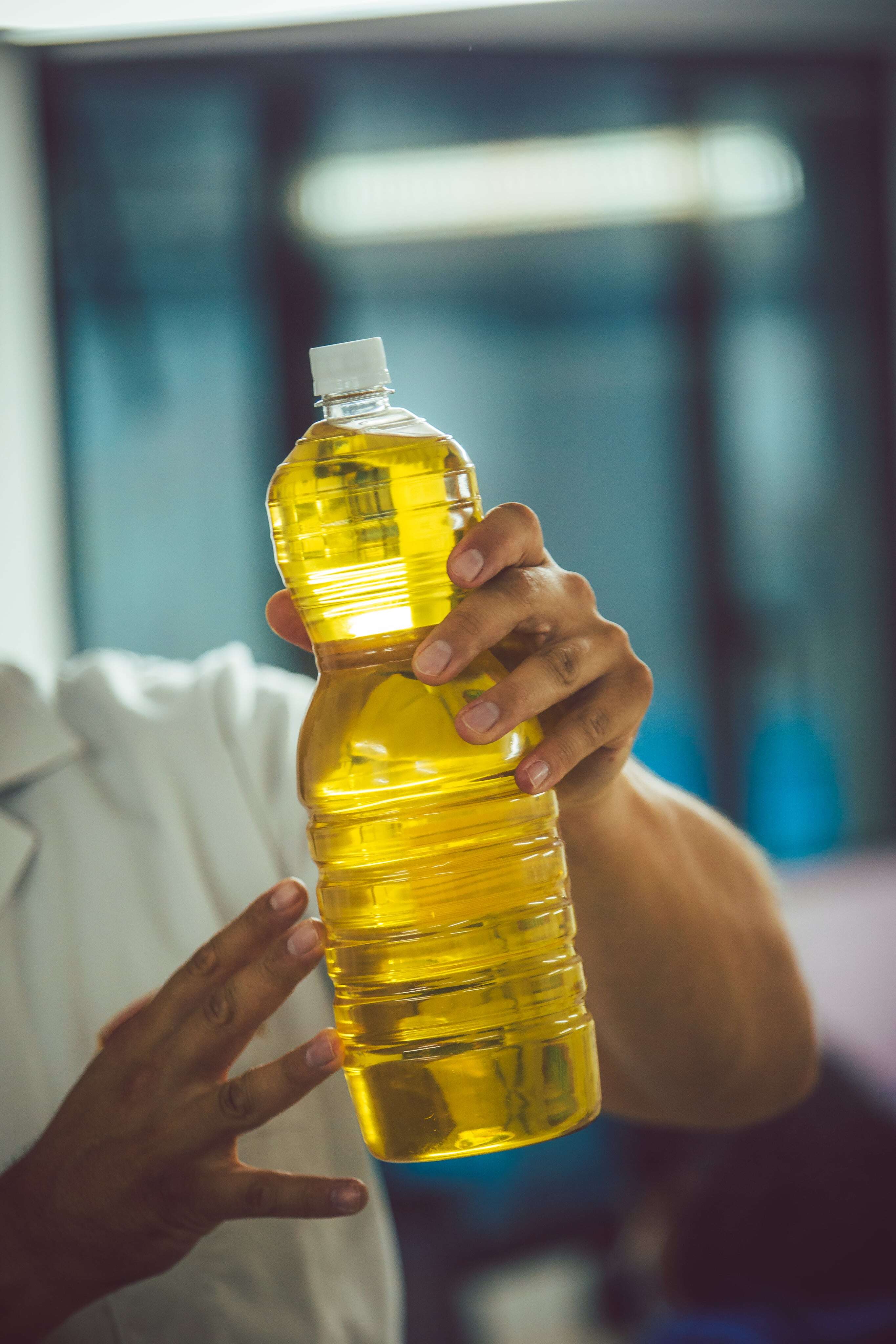 Hands-of-a-person-holding-an-oil-bottle-min